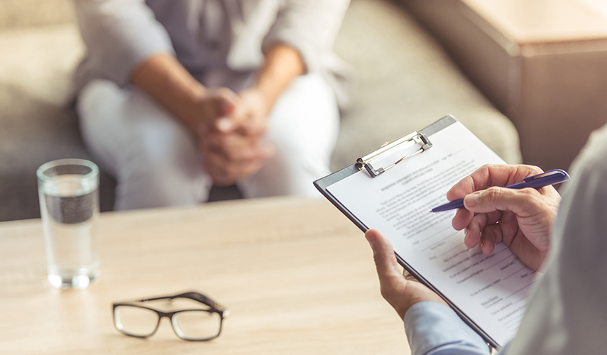 A psychologist fills out a form during a session