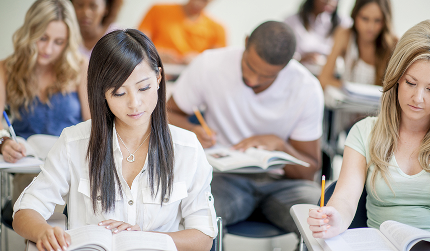 A classroom full of students reading textbooks