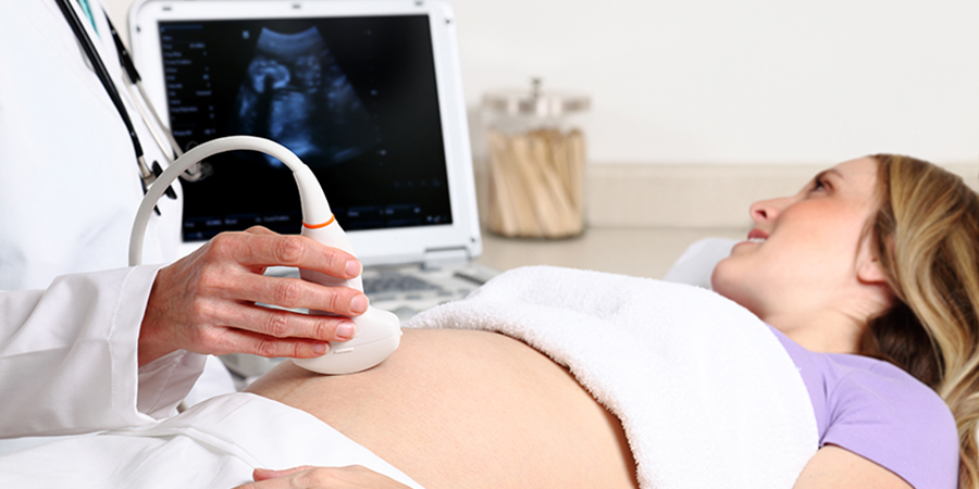 A sonographer uses ultrasound to look at a woman's thyroid