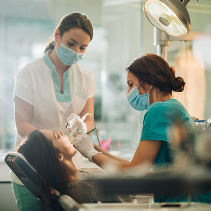 Woman getting treated at a dentists office.