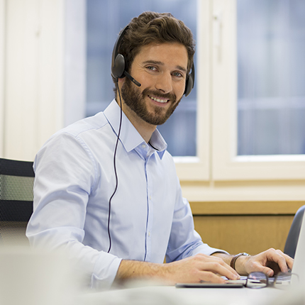 Man wearing a headset at a computer