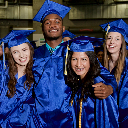 Four graduates in caps and gowns