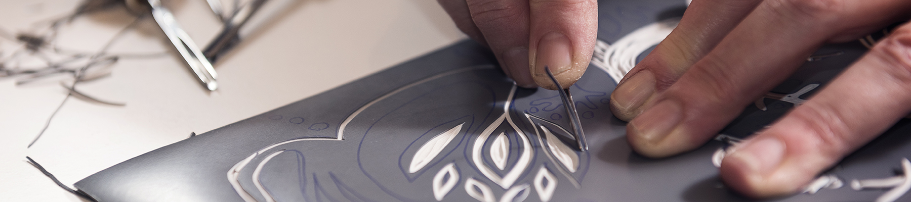 Hands carving a linoleum block to make a print