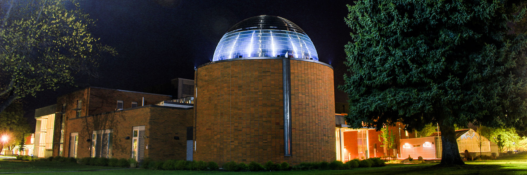 Outdoor view of the Science Building with the Planetarium in full view at night