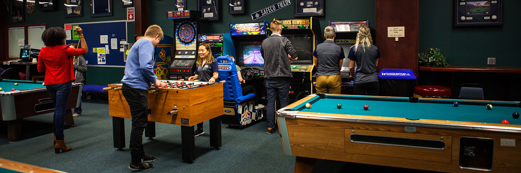 Students play foosball and pool in the Student Union Building rec room
