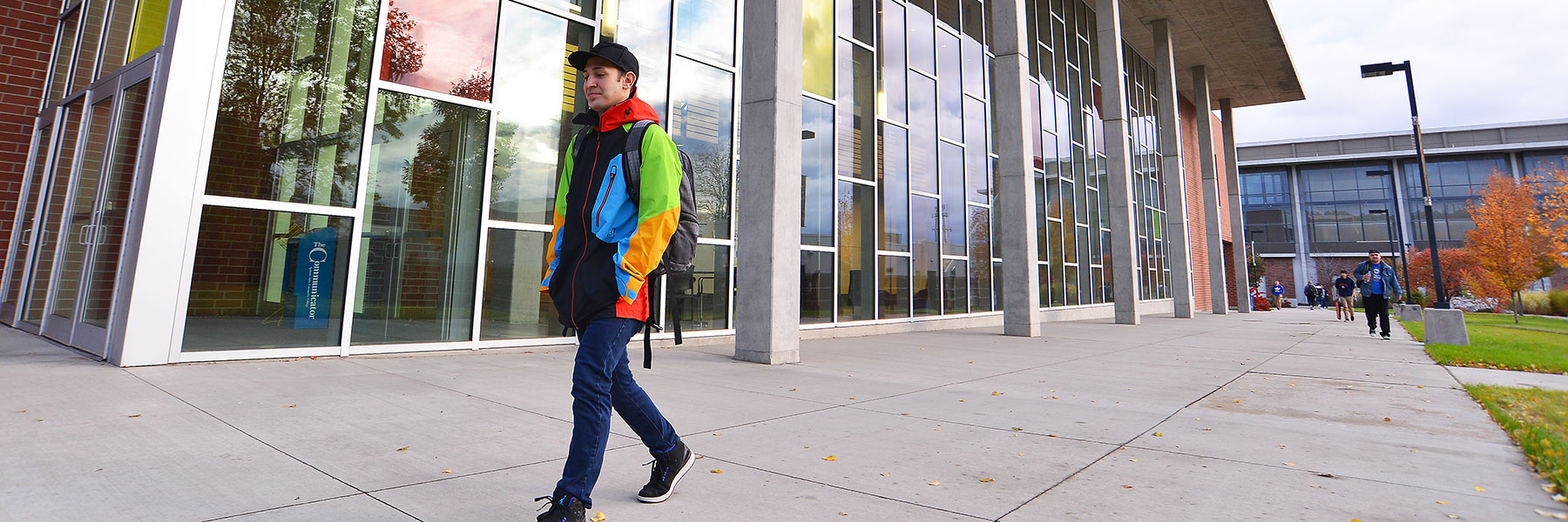 Student walking in front of the music building on the SFCC campus.