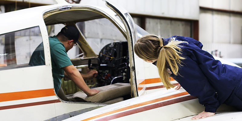 Aviation students working on a plane.