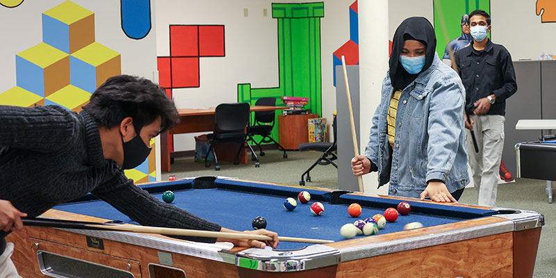 4 Students playing pool at SCC's game room