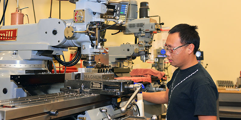 A Student Operating a Manufacturing Machine