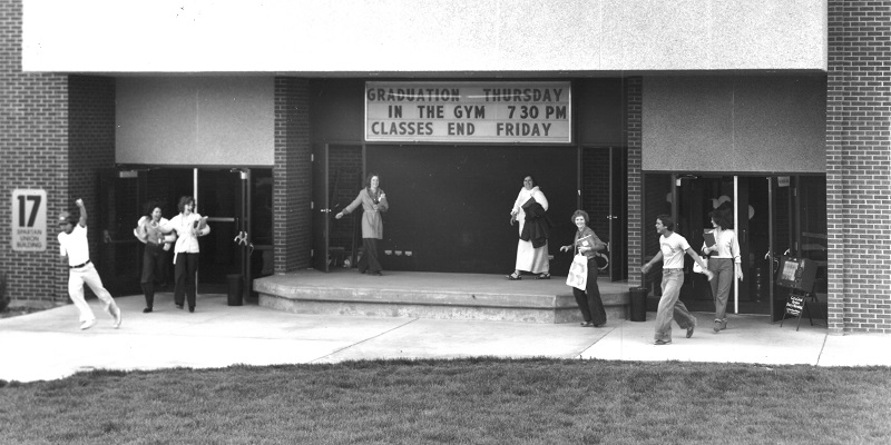Students exiting the student union building in the 1970s black and white