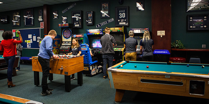 Students play foosball and pool in the Student Union Building rec room