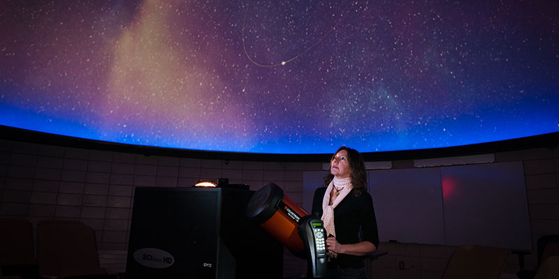 Instructor inside planetarium displaying night sky