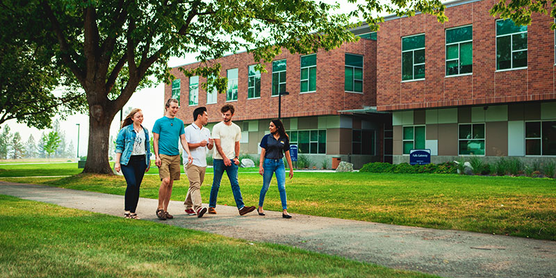 Five students walking through campus