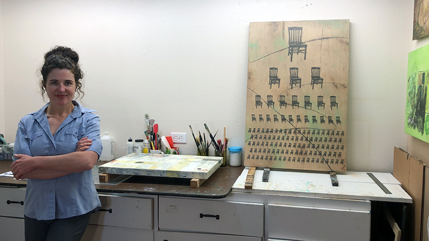 Sam Marroquin in her studio next to her art work