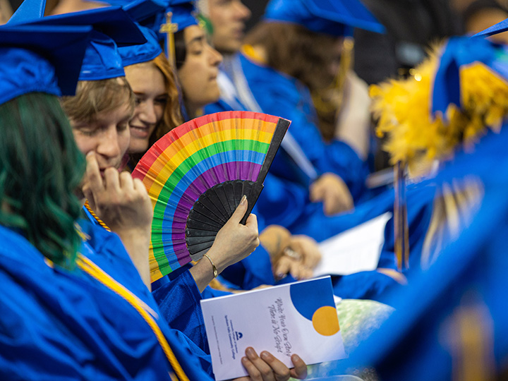 Student holding a rainbow fan.