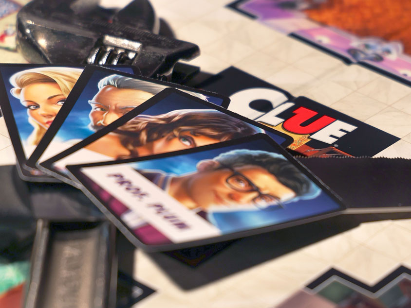 Clue board game with four-character cards and a wrench on the board.