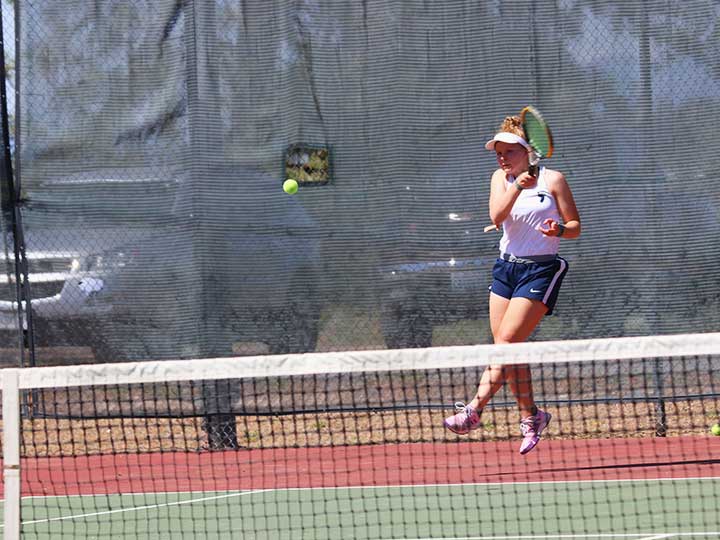 Women's tennis player returning the ball with one hand hit