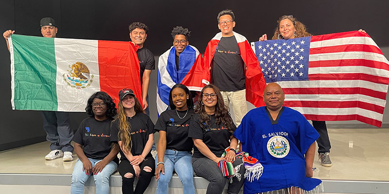 Ten LASO club members standing on a stage with 3 country's flags