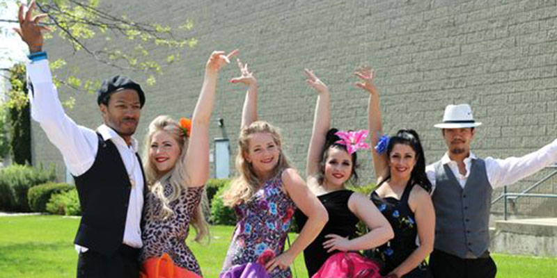 6 latin dance performers standing outside the student union building.
