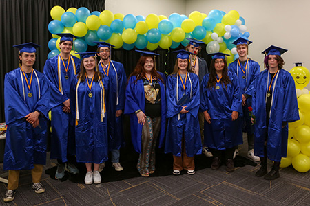 10 student standing in graudation robes