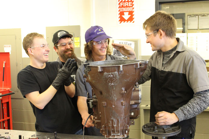 Four students working on a transmission