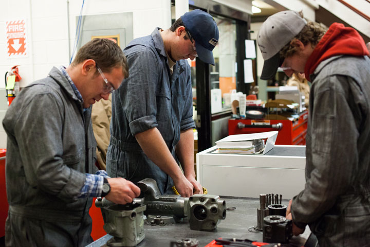 Students working on heavy equipment parts