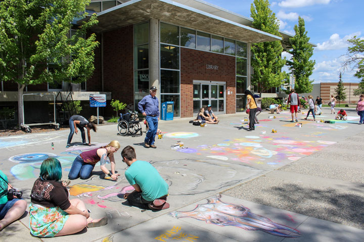 Students creating chalk art in front of the Library