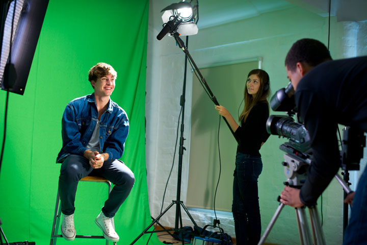 Students recording subject against a green screen