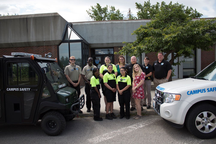11 members of Campus Security team standing by vehicles
