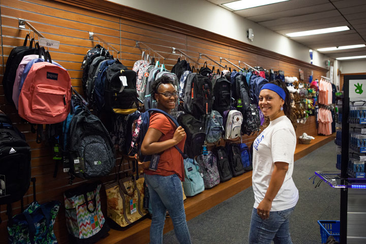 Two students shopping for backpacks at the Campus Bookstore