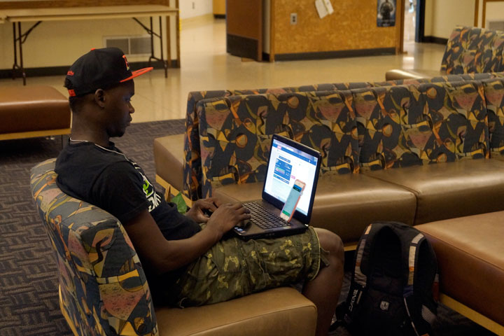 Student seated in SUB Lounge with laptop