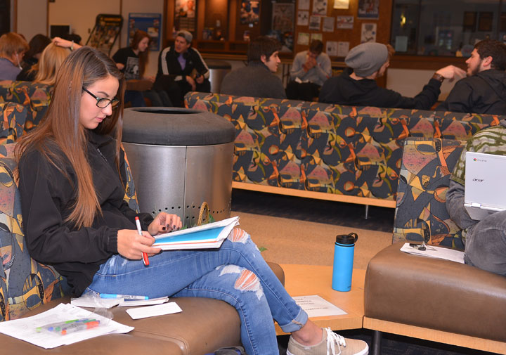 Student sitting in SUB Lounge with papers