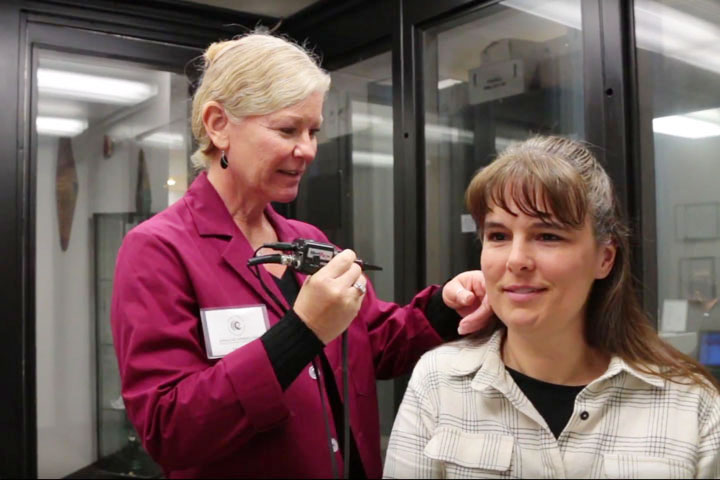 Hearing specialist checking ear with device