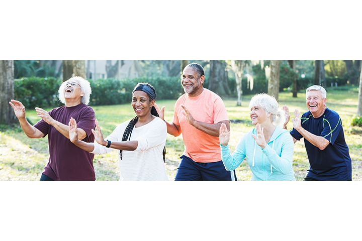 Five seniors exercising together in a park