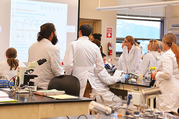 Science students in classroom wearing lab coats