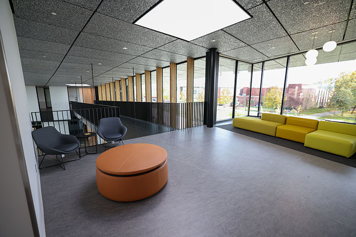 Study area inside of building 32. There is a small round table with two chairs and a couch.  